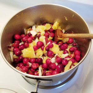 cranberries and oranges cooking in a pot on stove