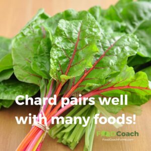 bunch of rainbow swiss chard leaves with brightly colored stems that are red, pink, orange or yellow on wood cutting board